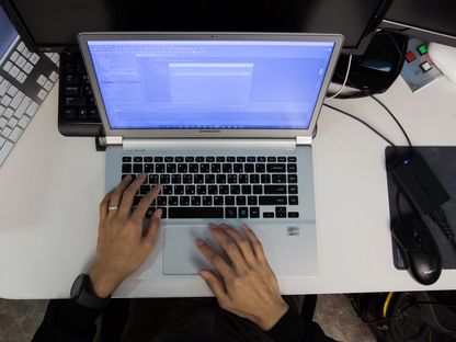 رجل يؤدي عمله على جهاز الكمبيوتر المحمول. - المصدر: بلومبرغ