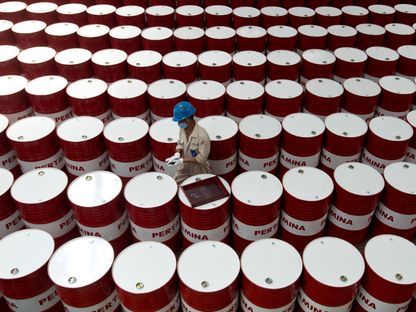 عامل يتفحص براميل منتجات نفطية لشركة الطاقة الإندونيسية \"برتامينا\" - المصدر: رويترز