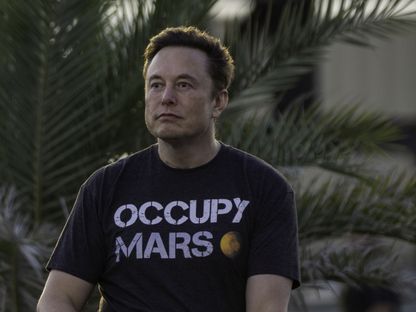 إيلون ماسك مرتدياً قميصاً كُتب عليه \"احتلوا المريخ\" (Occupy Mars) - المصدر: بلومبرغ