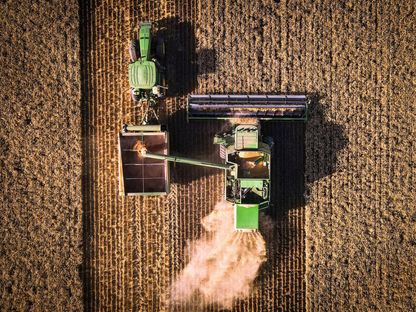 آلة الحصادة تعمل وتفرغ القمح في عربة حبوب خلال عملية الحصاد بحقل قرب مدينة غونيداه، في نيو ساوث ويلز في أستراليا - المصدر: بلومبرغ