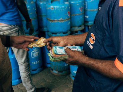 موظف يسلم النقود في محطة تعبئة بيلاوات ليترو غاز في كولومبو، سريلانكا. - المصدر: بلومبرغ