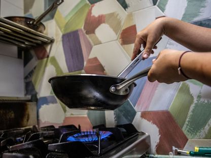 شخص يطبخ على موقد فرن يعمل بالغاز المنزلي في إحدى مناطق برشلونة، إسبانيا - المصدر: بلومبرغ