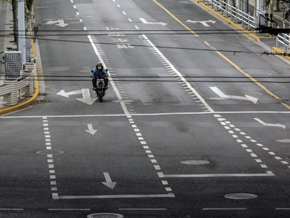عامل توصيل يقود دراجته في طريق شبه فارغ بسبب الإغلاق في مدينة شينغهاي، الصين. تسببت الإغلاقات في المدن الصينينة للسيطرة على تفشي الوباء، بانخفاض كبير في الطلب على الوقود - المصدر: بلومبرغ