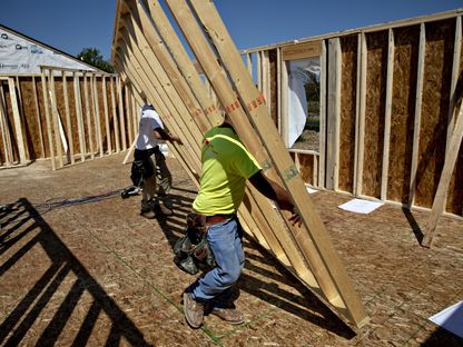 عاملان يرفعان جزءاً من جدار في منزل قيد البناء في مدينة بلانو بولاية إلينوي، الولايات المتحدة - المصدر: بلومبرغ