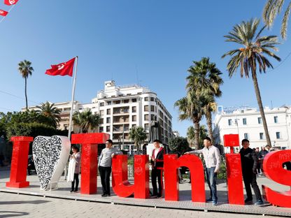 سياح يلتقطون صورة في أحد ميادين العاصمة تونس - المصدر: رويترز