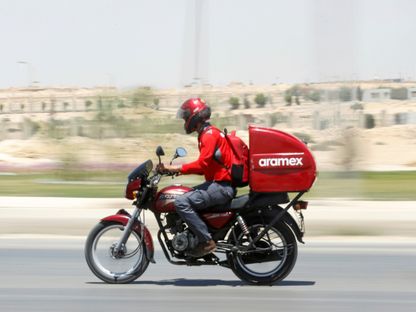 عامل في شركة \"أرامكس\" يقود دراجته النارية على الطريق السريع في القاهرة - المصدر: رويترز