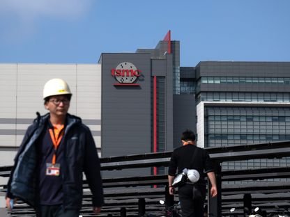 عاملان يسيران في محيط المقر الرئيسي لشركة TSMC في حديقة هسينشو للعلوم، هسينشو، تايوان - الشرق/بلومبرغ