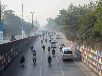 المركبات على طول طريق سريع يكتنفه الضباب الدخاني في لاهور، باكستان. - المصدر: بلومبرغ