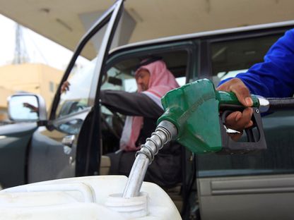 عمل يملأ عبوة بالوقود فيما ينتظر رجل في مركبته المتوقفة في محطة للوقود، الرياض، السعودية - المصدر: بلومبرغ