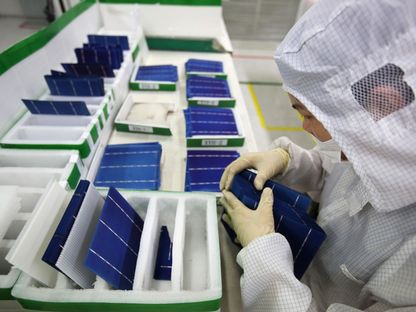 أحد العمال يجري اختبارات نهائية عند خط إنتاج للخلايا الشمسية داخل مصنع تابع لشركة \"ترينا سولار\" في مقاطقة جيانغسو، الصين - المصدر: بلومبرغ