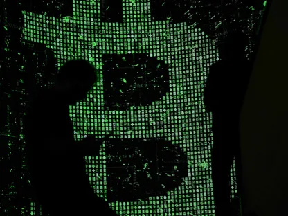 رجل يحمل هاتفه يمر من أمام لوحة إلكترونية تظهر شعار \"بتكوين\" - بلومبرغ