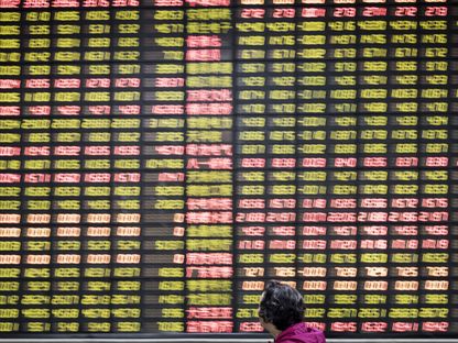 مستثمر ينظر إلى لوحة الأسهم الإلكترونية في شركة وساطة للأوراق المالية في شنغهاي، الصين، يوم الجمعة، 9 يونيو 2017. - المصدر: بلومبرغ