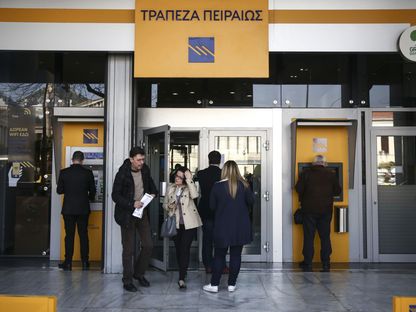 عملاء يستخدمون ماكينة الصراف الآلي بفرع لمصرف \"بيريوس بنك\" في أثينا - المصدر: بلومبرغ