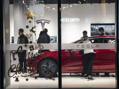 متسوقون يعاينون سيارة تسلا في أحد المعارض بمدينة شنغهاي الصينية - المصدر: بلومبرغ
