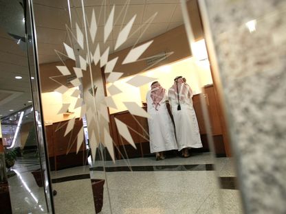 متعاملان يقفان في صالة الاستقبال بسوق أبوظبي المالية، في أبوظبي - المصدر: بلومبرغ