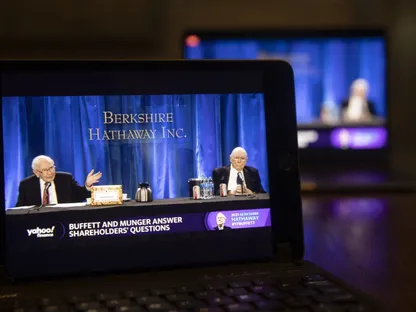 وارن بافيت، رئيس مجلس إدارة شركة بيركشاير هاثاواي ورئيسها التنفيذي حينئذ إلى اليسار، وتشارلي مونغر، نائب رئيس مجلس إدارتها، يتحدثان خلال الاجتماع السنوي الافتراضي للمساهمين على جهاز كمبيوتر محمول في تيسكيلوا بولاية إلينوي الأميركية في 1 مايو 2021 - بلومبرغ