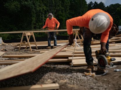 عاملان يجهزان ألواحاً خشبية في موقع للبناء في ليلينغتون، ولاية كارولاينا الشمالية، الولايات المتحدة - المصدر: بلومبرغ