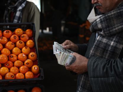 زبون يعدّ أوراقاً نقدية من العملة المصرية داخل أحد الأسواق في القاهرة - الشرق/بلومبرغ