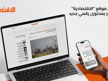 صورة تظهر الموقع الإلكتروني لصحيفة الاقتصادية كما يظهر على شاشتي حاسوب وهاتف ذكي - المصدر: بلومبرغ