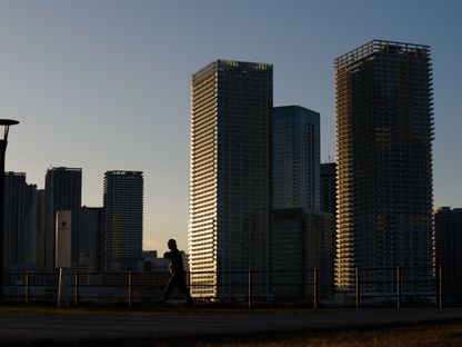 رجل يمشي بالقرب من المباني السكنية في منطقة تويوسو في طوكيو، اليابان - المصدر: بلومبرغ