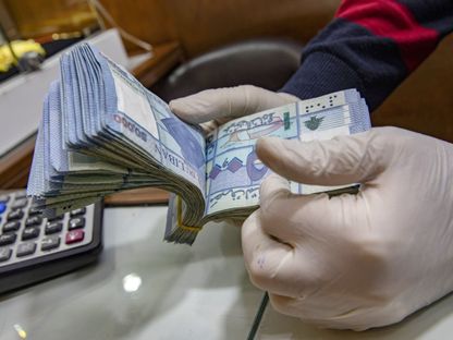 أحد الصرّافين يعدّ أوراقاً نقدية من فئة 50,000 ليرة في أحد مكاتب الصرافة في شارع الحمرا، في العاصمة اللبنانية بيروت، يوم 14 أبريل 2021 - المصدر: بلومبرغ
