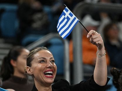 امرأة ترفع علم اليونان - المصدر: بلومبرغ
