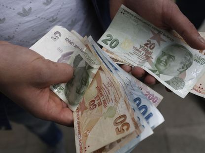 عميل يعد الأوراق النقدية بالليرة التركية بإحدى محال الصرافة في إسطنبول، تركيا - المصدر: بلومبرغ
