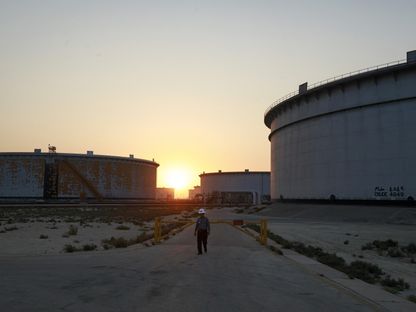 موظف يسير أمام صهاريج تخزين النفط الخام في مزرعة صهاريج الجعيمة التابعة لشركة أرامكو المملكة العربية السعودية - المصدر: بلومبرغ