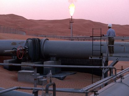 عامل يقف عند خط أنابيب ويراقب إنتاج ومعالجة النفط في حقل تابع لشركة \"أرامكو\" بمنطقة الشيبة، صحراء الربع الخالي، المملكة العربية السعودية - المصدر: بلومبرغ