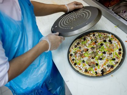 طاهٍ يعد بيتزا لطلب الوجبات الجاهزة في الرياض، المملكة العربية السعودية. المصور: تسنيم السلطان / بلومبرج - المصدر: بلومبرغ