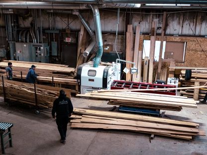 عمال يشغلون منشار لقطع الألواح الخشبية المستصلحة  في منشرة شركة \"هدسون\" في باين بلينز، نيويورك، الولايات المتحدة - المصدر: بلومبرغ