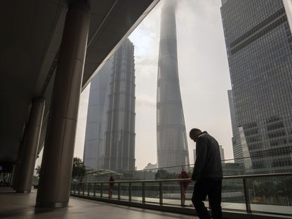 مشاة يسيرون أمام المباني في منطقة لوجيازوي المالية، بودونغ، شنغهاي، الصين - المصدر: بلومبرغ