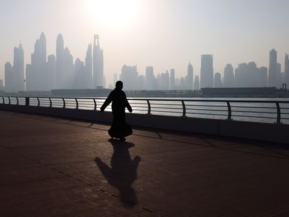 زائر يمشي على طول الكورنيش، وفي الخلفية ناطحات السحاب في أفق المدينة، في دبي، الإمارات العربية المتحدة، يوم الأربعاء، 29 نوفمبر 2023 - المصدر: بلومبرغ