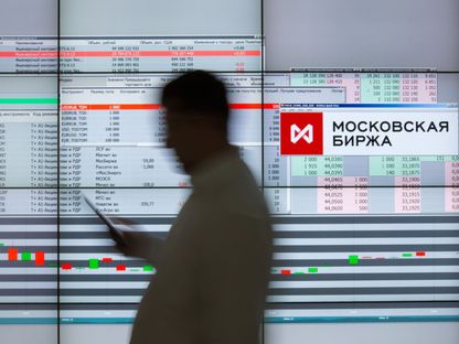 زائر يمر من أمام شاشة إلكترونية تعرض أسعار الأسهم في بورصة موسكو. موسكو، روسيا - المصدر: بلومبرغ