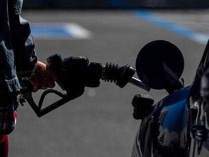 شخص يحمل مضخة وقود في محطة وقود تابعة لشركة شيفرون، كاليفورنيا - المصدر: بلومبرغ