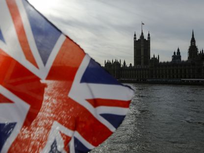 علم الاتحاد البريطاني ، المعروف أيضا باسم \" جاك الاتحاد\"، يرفرف من كشك لبيع الهدايا التذكارية السياحية على ضفة نهر التايمز أمام مبنى البرلمان في لندن المملكة المتحدة يوم الأربعاء 30 أكتوبر2019. - المصدر: بلومبرغ