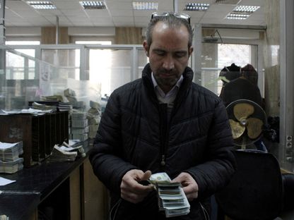 موظف يعدّ النقود في البنك المركزي السوري بعد الإطاحة بنظام بشار الأسد. 12 يناير 2025 - رويترز