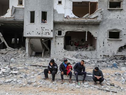 سكان يجلسون بالقرب من منازلهم المدمرة في أعقاب الغارات الجوية الإسرائيلية على رفح في 29 مارس - المصدر: بلومبرغ