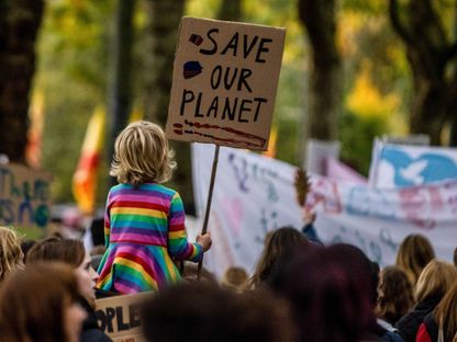 طفلة تحكل لافت تقول أنقذوا كوكبنا إبان انعقاد قمة المناخ في غلاسكو في اسكتلندا - المصدر: بلومبرغ