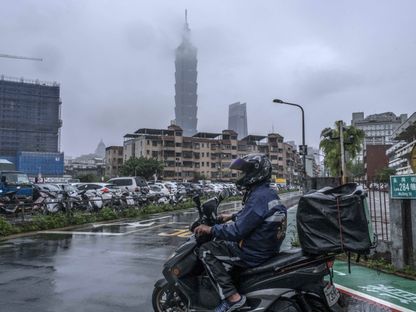 راكب دراجة بخارية يمر أمام المبنى \"تايبيه 101\"، في تايوان - المصدر: بلومبرغ