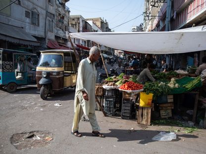 رجل يمشي في سوق خضار في كراتشي في الباكستان - المصدر: بلومبرغ