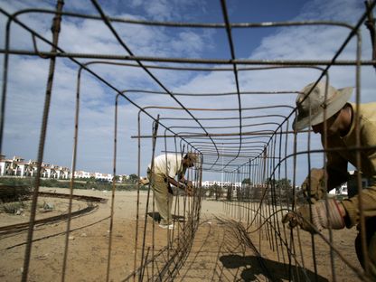 عاملان في موقع بناء في مدينة السعيدية الواقعة على ساحل البحر الأبيض المتوسط، المغرب - المصدر: رويترز