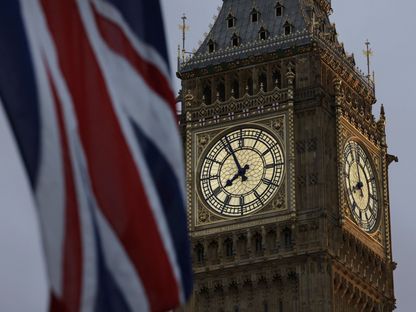 علم بريطانيا يرفرف بالقرب من ساعة \"بيغ بين\" في وستمنستر، لندن، المملكة المتحدة - المصدر: بلومبرغ