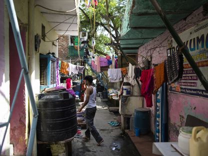 أحد السكان يمر بجوار غسيل ملابس سكان حي \"لال غومباد باستي\" للعمال المهاجرين في نيودلهي، الهند - المصدر: بلومبرغ