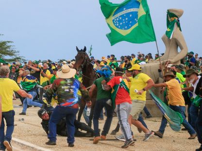 ضابط شرطة يسقط من على صهوة جواده خلال اشتباكات مع أنصار الرئيس السابق، جايير بولسونارو، بعد اقتحام المحتجين قصر بلانالتو الرئاسي في العاصمة برازيليا، البرازيل، يوم الأحد 8 يناير 2023 - AFP