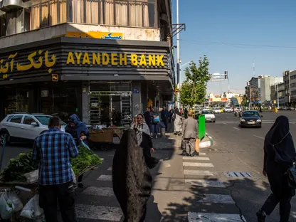 مشاة يعبرون الطريق أمام فرع بنك آينده في طهران، إيران - بلومبرغ