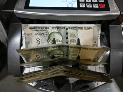 أوراق نقدية من الروبية الهندية داخل آلة لعد النقود - بلومبرغ