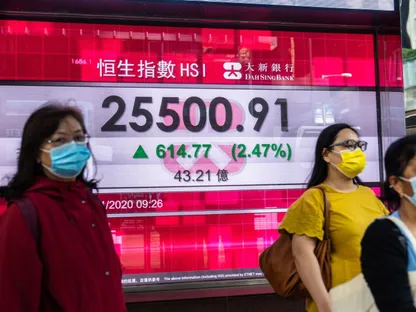 مشاة يعبرون من أمام لوحة تعرض أسعار مؤشر \"هانغ سينغ\" في هونغ كونغ - المصدر: بلومبرغ