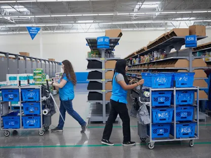 موظفتان تجمعان الطلبات الإلكترونية في مركز تنفيذ الطلبات التابع لـ\"ولمارت\" في مدينة غرايبفاين بولاية تكساس. - بلومبرغ