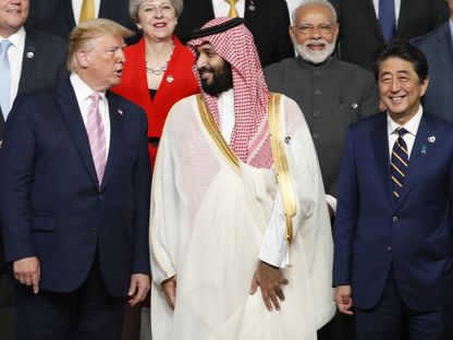 ولي العهد السعودي الأمير محمد بن سلمان يتبادل أطراف الحديث مع الرئيس الأميركي دونالد ترمب، وإلى يساره رئيس الوزراء الياباني شينزو آبي، وفي الخلفية عدد من القادة، خلال جلسة تصوير في قمة مجموعة العشرين في أوساكا، اليابان يوم الجمعة 28 يونيو 2019 - بلومبرغ